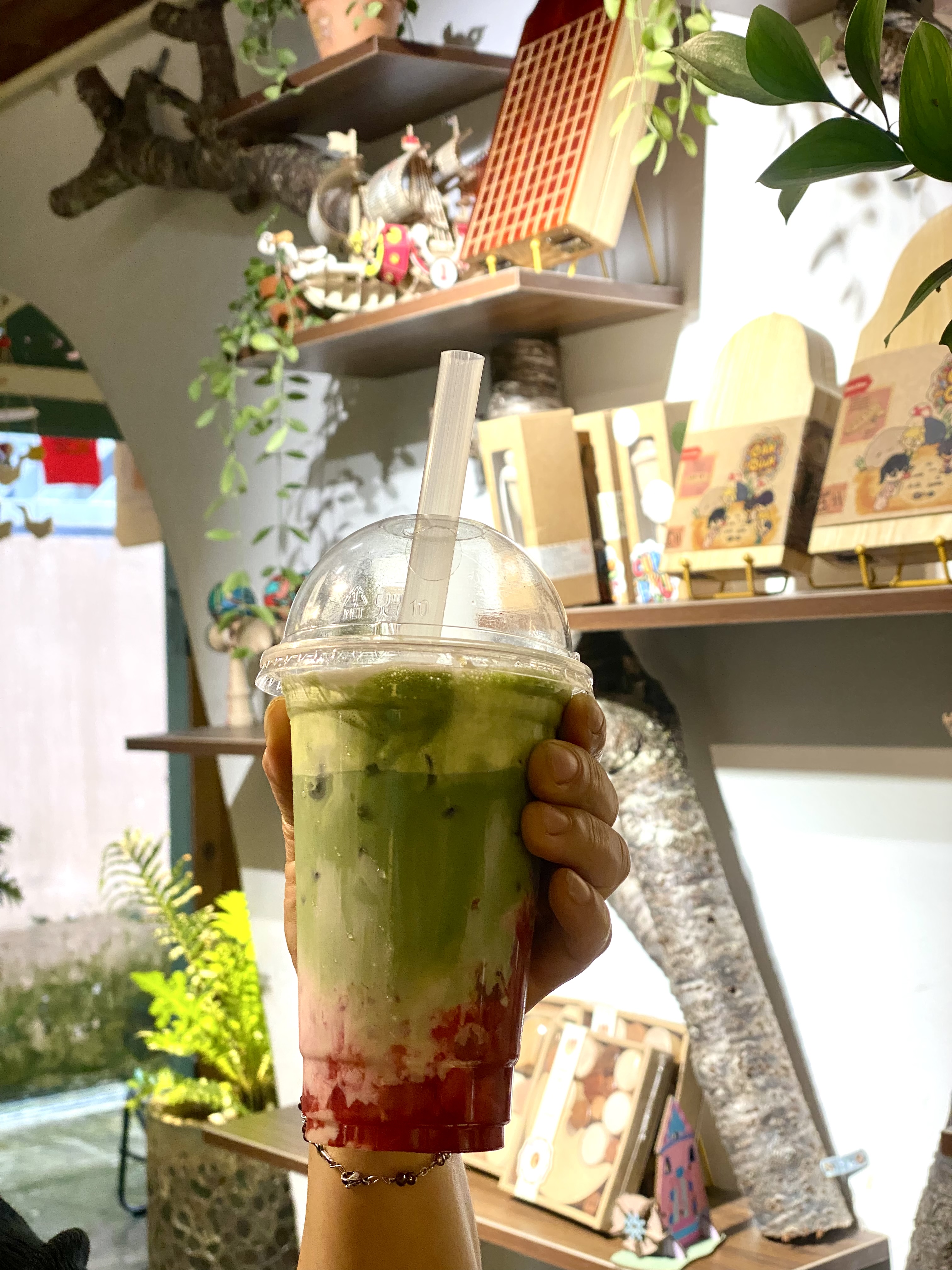 Khoảng sân trước quán Nhỏ Café and Clothing với ánh đèn vàng và mặt tiền gỗ