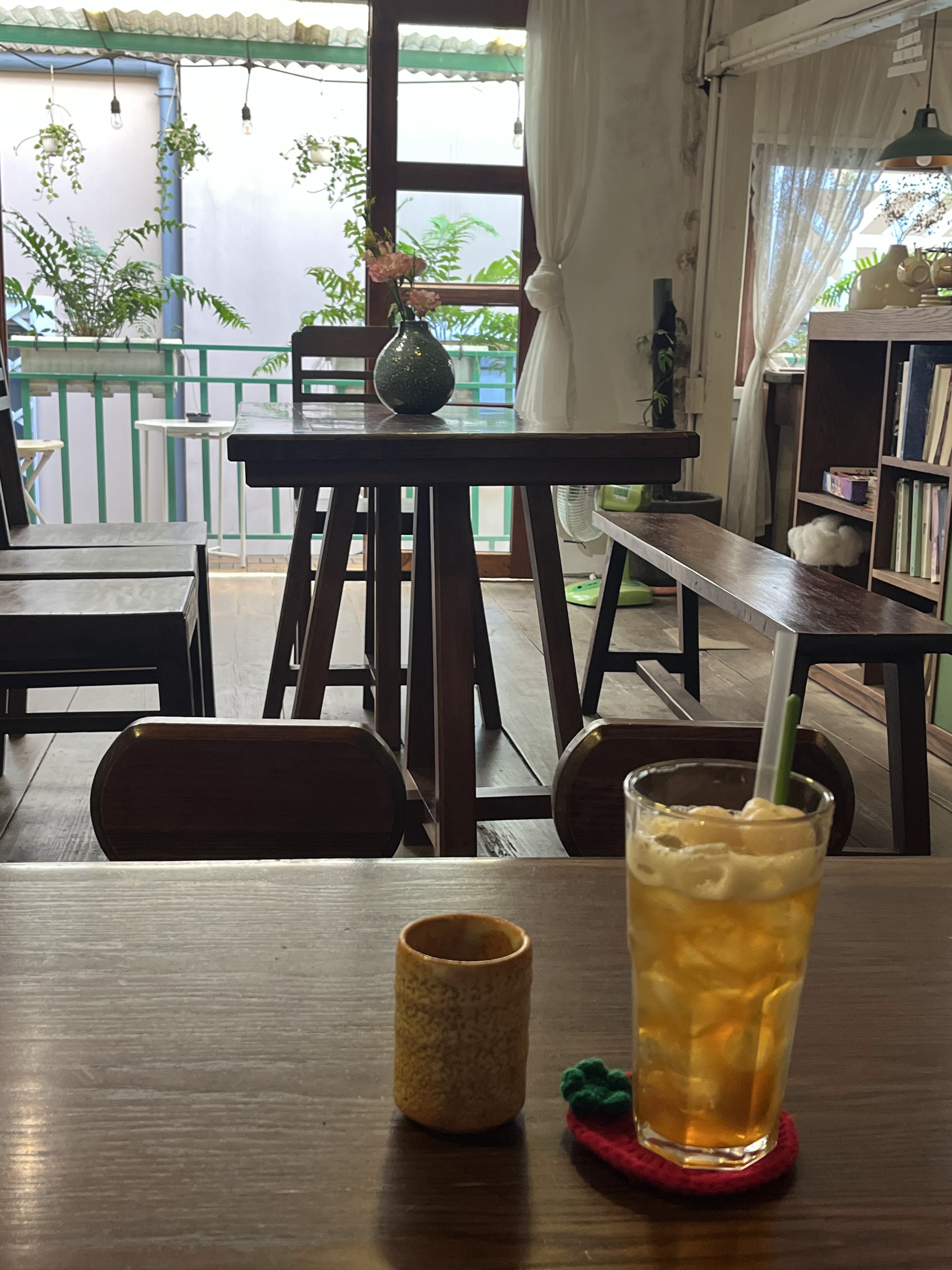 Bộ ấm trà và ly thủy tinh trên khay gỗ trong góc đọc sách